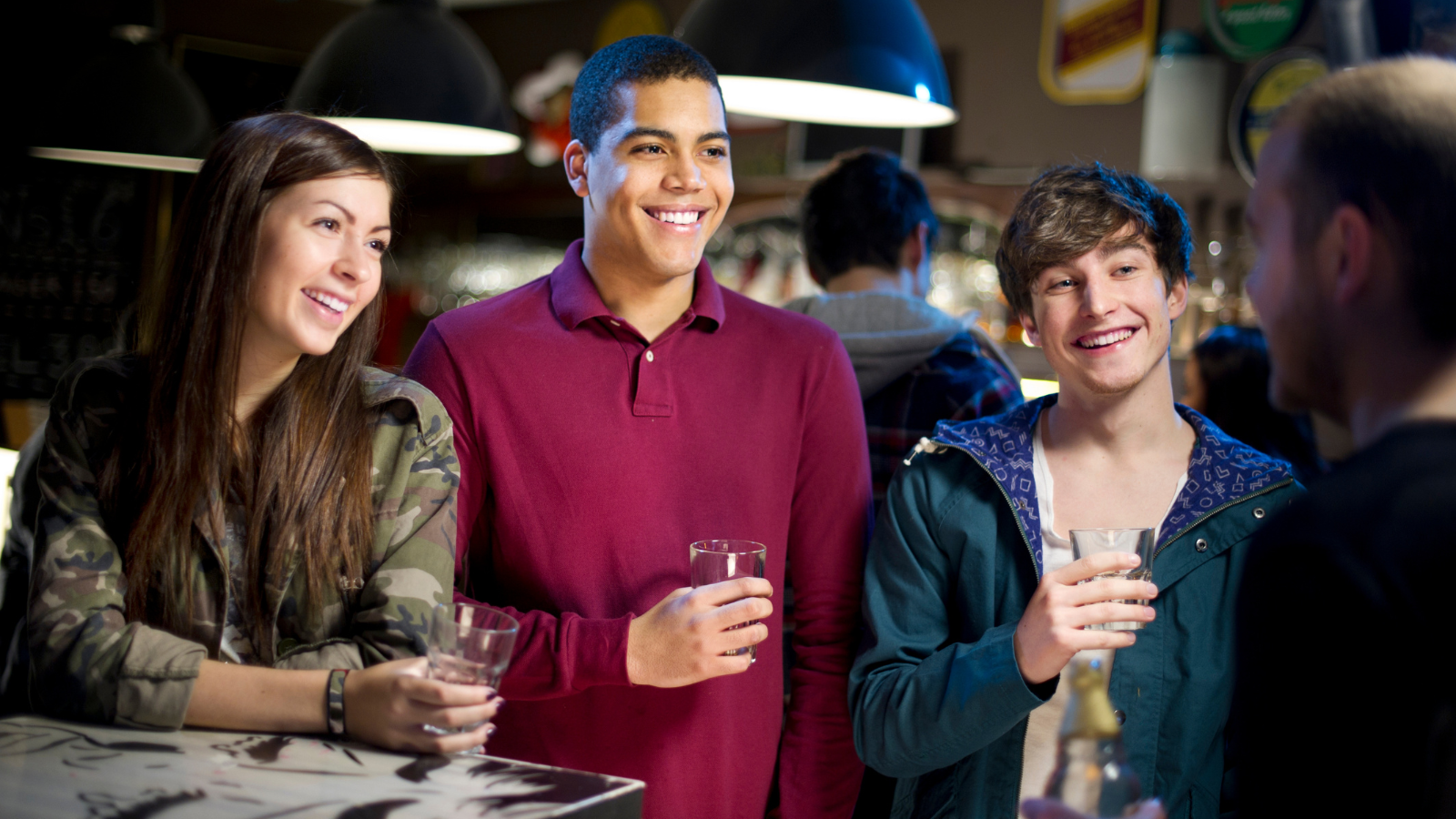 Three students chatting over drinks